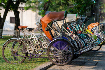 Vintage many trishaw stop beside road for service traveller on the street in Vietnam, closeup - obrazy, fototapety, plakaty