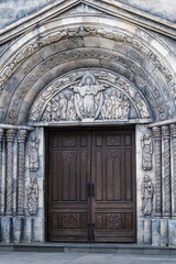 Facade of old medieval church, detail of a wooden door and gothic sculptures, Danang, Vietnam