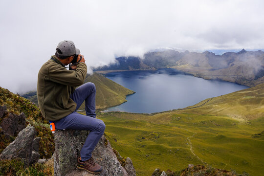 Man taking photo of lake in mountains