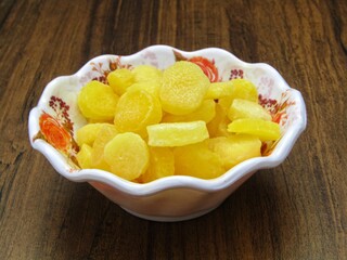 Dried pineapple sliced in a bowl on wooden background 