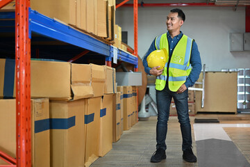 Portrait of man warehouse workers standing in aisle between rows of tall shelves full of packed boxes