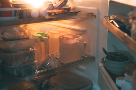Open fridge with water bottle and food mix storage