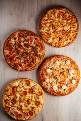 pizza on a wooden table, several types