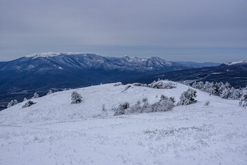 Fototapeta na wymiar View to Babugan-Yaylai mountain from Southern Demerdzhi in snow and ice in spring. Crimea