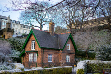 Fototapeta na wymiar Prince Street Garden , Beautiful garden and old bricks house in Edinburgh old towns near Edinburgh castle during winter snow evening at Edinburgh , Scotland : 27 February 2018