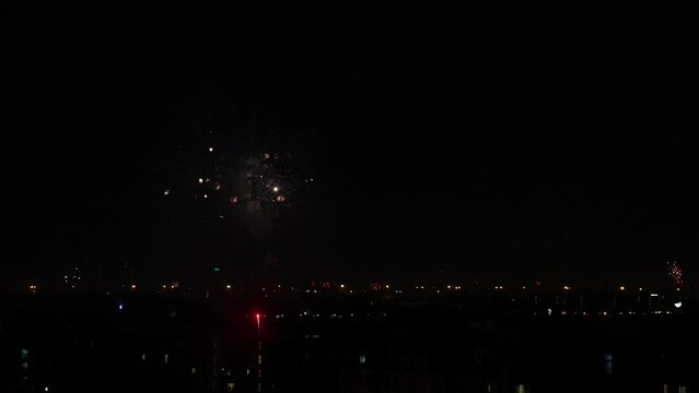 Slow Motion of Burst Spreading Fireworks Being Set Off Between Building At Night City
