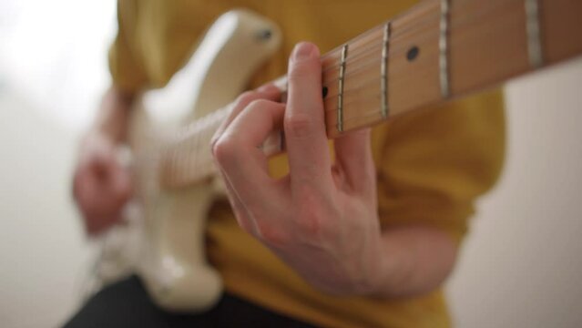Man playing chords on an electric guitar. Fender Stratocaster