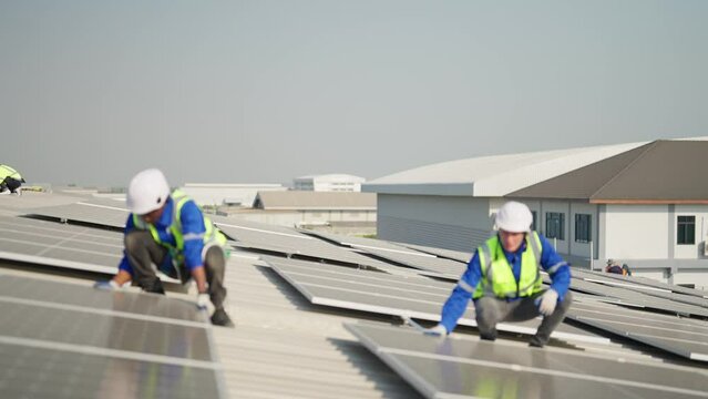 Engineer on rooftop sitting next to solar panels photo voltaic check alignment for good installation