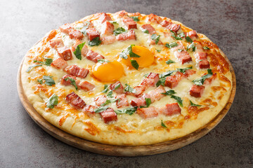 Tasty Pizza Carbonara with Bacon and Yolk closeup on the wooden board on the table. Horizontal