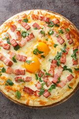 Homemade Pizza Carbonara with Bacon, Egg and Cheese closeup on a wooden board over stone table background. Vertical top view from above