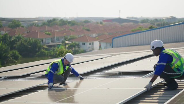 Engineer on rooftop sitting next to solar panels photo voltaic check alignment for good installation