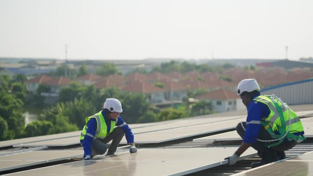 Engineer on rooftop sitting next to solar panels photo voltaic check alignment for good installation