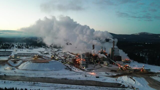 Wintertime Pollution at Pulp Mill in Cranbrook, British Columbia: Aerial View of Industrial Facility and Machinery Turning Timber into Wood Pulp