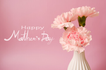 Mother's day concept floral background. Happy Mother's day lettering on beautiful pink Carnation flower and pink background. 