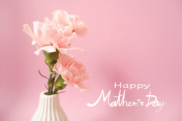 Mother's day concept floral background. Happy Mother's day lettering on beautiful pink Carnation flower and pink background. 