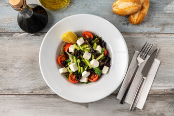Mediterranean salad with olives and cheese on a white porcelain plate