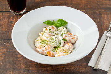 different types of pelmeni or russian dumplings in white plate on wooden background