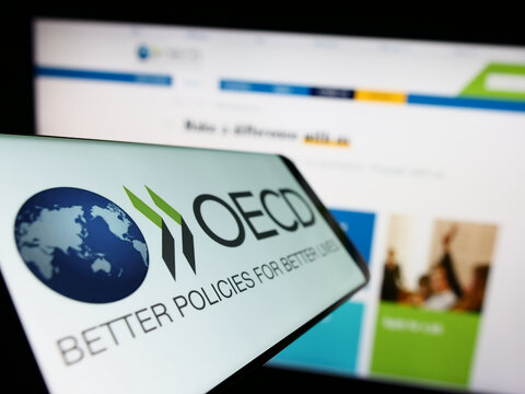 Stuttgart, Germany - 12-23-2022: Smartphone with logo of intergovernmental organisation OECD on screen in front of website. Focus on center-left of phone display.