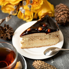 Piece of cake with chocolate fondant on plate. Dessert on table with cup of tea. Decoration of...