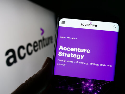 Stuttgart, Germany - 12-23-2022: Person holding cellphone with webpage of information technology company Accenture plc on screen with logo. Focus on center of phone display.