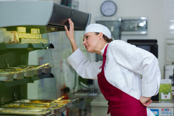 buffet female worker servicing food in cafeteria