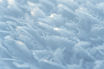 Fototapeta na wymiar Thin crust of ice over snow, hoarfrost. Texture or background