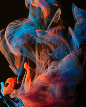 A mixture of colorful ink swirls in water on a black background. Abstract concept photo