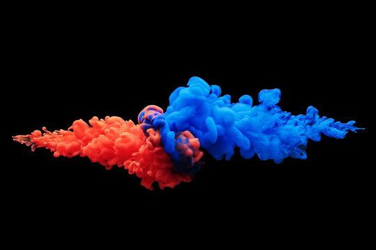 Collision of flow of red and blue ink on a black background. Abstract concept photo