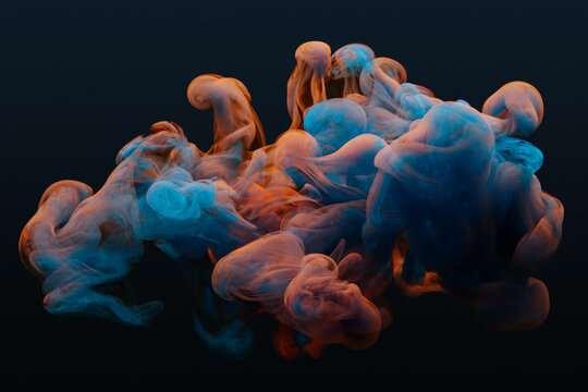 Collision of flow of red and blue ink on a dark background. Abstract concept photo