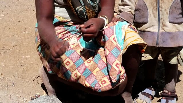 Close up of unrecognizable Hadzabe woman plucking a hunted bird. Static, day