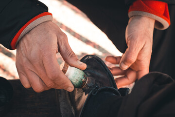 Close-up of the hands of a shoe cleaner cleaning the shoes of its client. Berat, Albania.