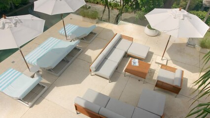 Top shot of luxury terrace with sun beds, sofas, tables and umbrellas