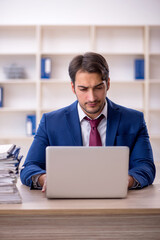 Young male employee and too much work in the office