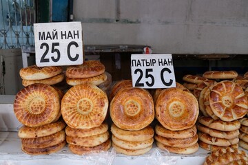 Stand of local bread in Osh Bazaar, central market in Bishkek, Kyrgyzstan. Traditional Kyrgyz bread named lipioshka, sold at a city bazaar.	
