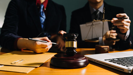 Business and lawyers discussing contract papers with brass scale on desk in office. Law, legal services, advice, justice and law concept picture with film grain effect