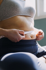 Beautiful fat woman with tape measure She uses her hand to squeeze the excess fat that is isolated on a white background. She wants to lose weight, the concept of surgery and break down fat under the