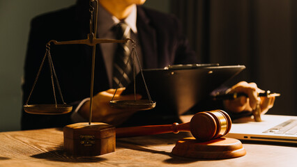 Business and lawyers discussing contract papers with brass scale on desk in office. Law, legal services, advice, justice and law concept picture with film grain effect