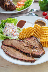 Delicious grilled beef steak and rustic potatoes wedges with vegetable salad served on white plate