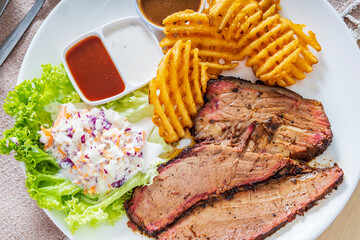 Delicious grilled beef steak and rustic potatoes wedges with vegetable salad served on white plate