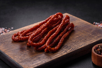Delicious thin smoked meat sausages with spices and herbs