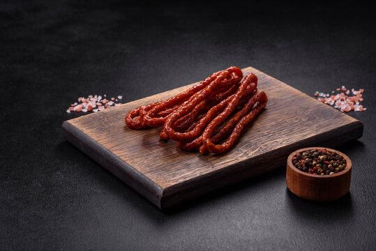 Delicious thin smoked meat sausages with spices and herbs