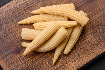 A bunch of small white canned corn on a dark concrete background