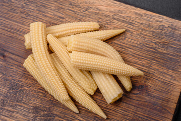A bunch of small white canned corn on a dark concrete background