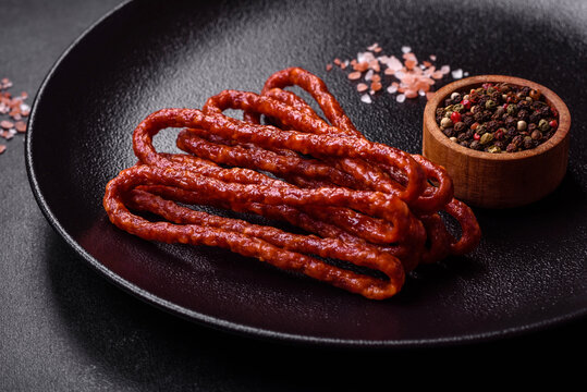 Delicious thin smoked meat sausages with spices and herbs