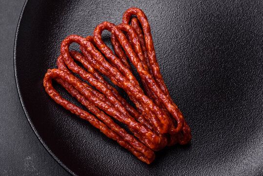 Delicious thin smoked meat sausages with spices and herbs