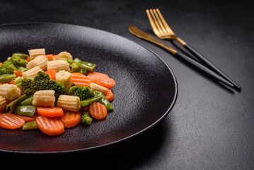 A mixture of vegetables: carrots, small heads of corn, asparagus beans steamed