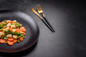 A mixture of vegetables: carrots, small heads of corn, asparagus beans steamed