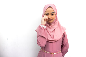 Beautiful young Asian woman in pink hijab rubs tears wants to cry feels depressed has a problem isolated on white background