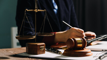 Business and lawyers discussing contract papers with brass scale on desk in office. Law, legal services, advice, justice and law concept picture with film grain effect