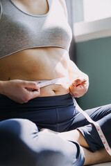 Beautiful fat woman with tape measure She uses her hand to squeeze the excess fat that is isolated on a white background. She wants to lose weight, the concept of surgery and break down fat under the